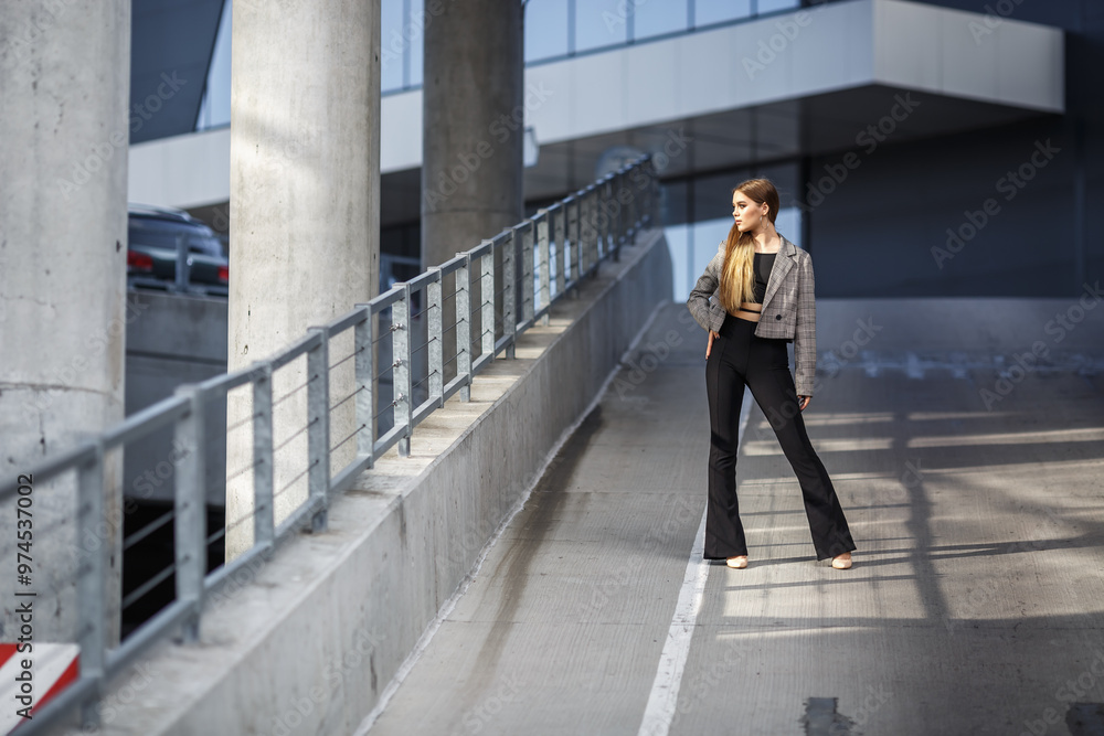 young girl with sunglasses in jacket posing near modern office building with mirrored walls in parking lot with road signs young girl with sunglasses in jacket posing near modern office building with mirrored walls in parking lot with road signs