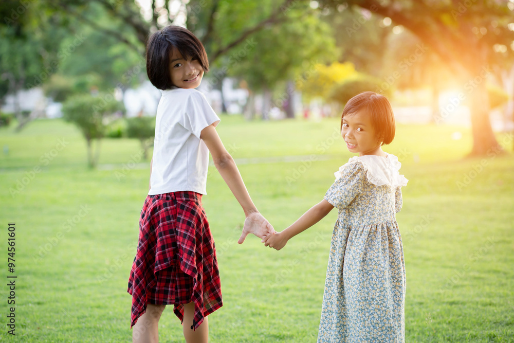 Two young girls are hugging each other in a park Two young girls are hugging each other in a park