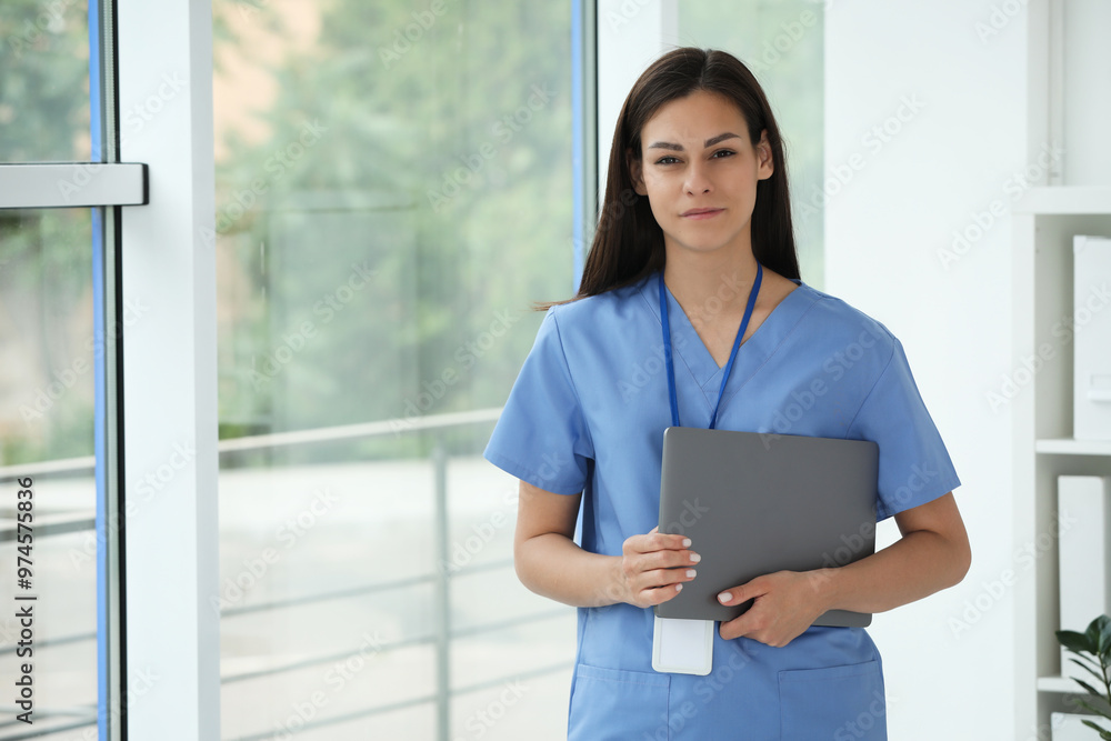 Beautiful nurse with laptop in hospital office. Space for text Beautiful nurse with laptop in hospital office. Space for text