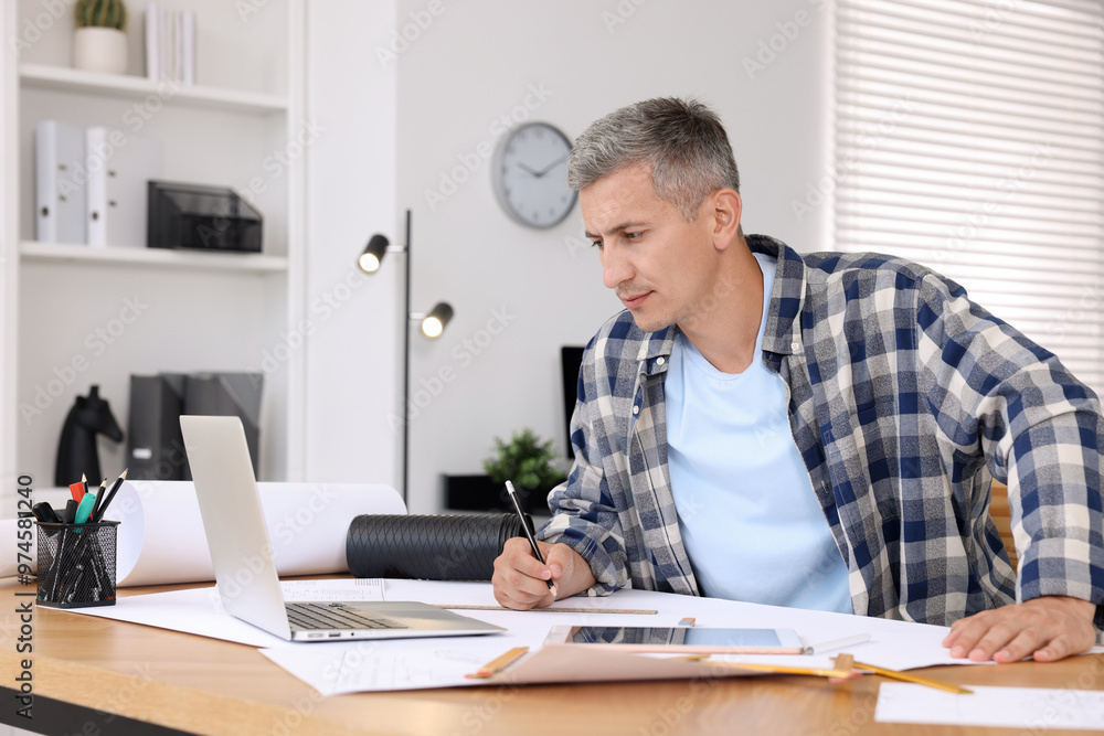 Architect making engineering drawing at wooden table in office Architect making engineering drawing at wooden table in office