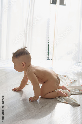 a baby crawling on the floor in front of a window photo