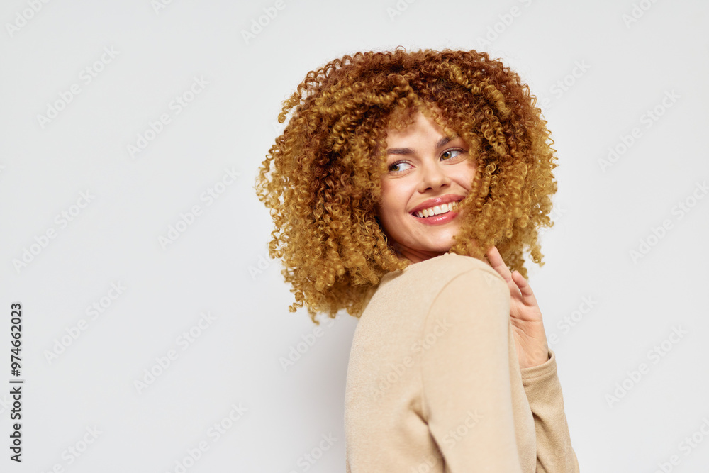 Woman with curly hair smiling against a plain light background Her joyful expression highlights her confidence and beauty, showcasing natural hairstyles in everyday settings Woman with curly hair smiling against a plain light background Her joyful expression highlights her confidence and beauty, showcasing natural hairstyles in everyday settings