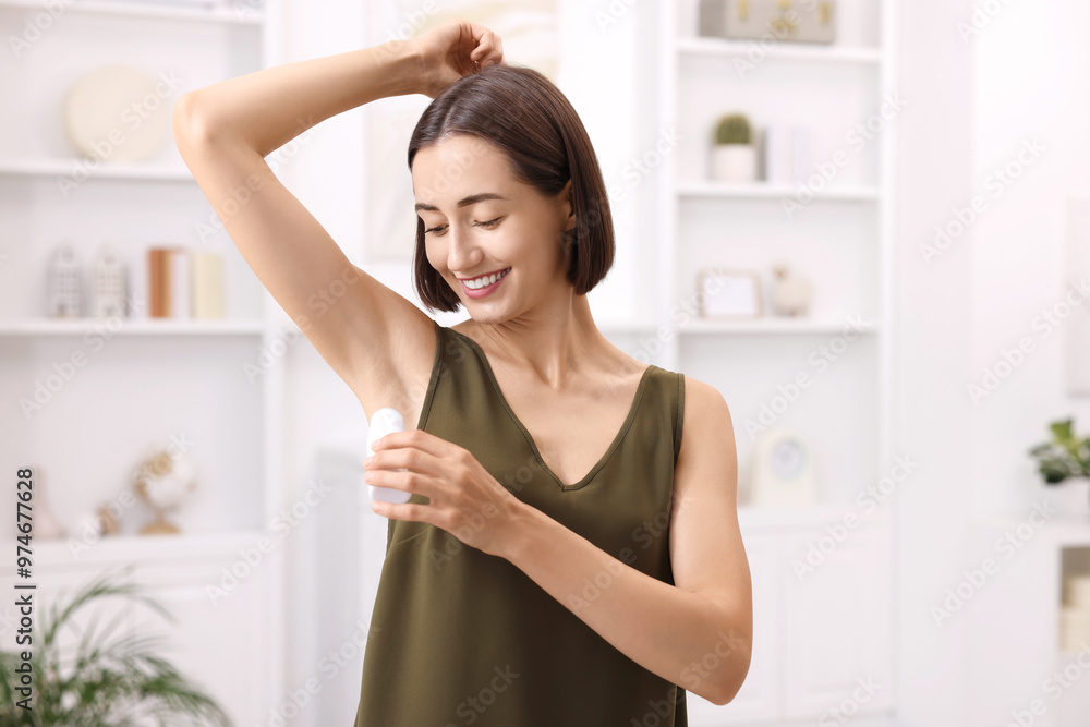 Smiling woman applying roll-on deodorant at home Smiling woman applying roll-on deodorant at home
