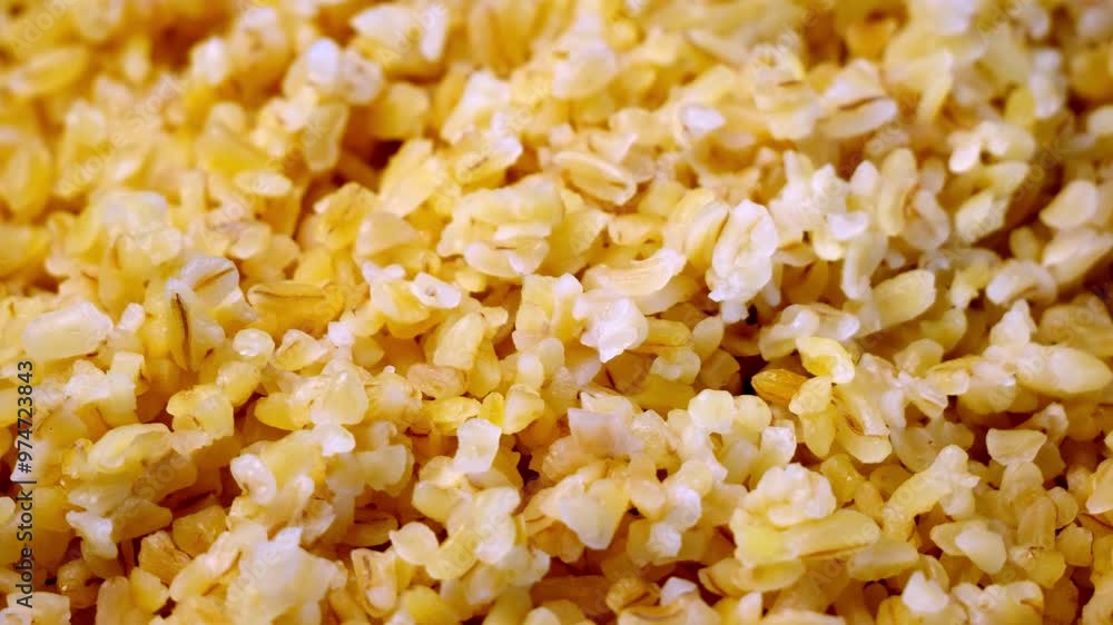 A collection of cooked bulgur wheat, displaying its uniform size and slightly flattened shape. A collection of cooked bulgur wheat, displaying its uniform size and slightly flattened shape.