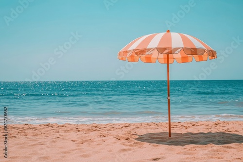 A Striped Beach Umbrella on a Sandy Beach with Ocean in the Background