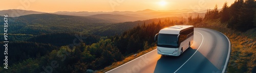 A scenic view of a bus traveling along a winding road during a beautiful sunset in a mountainous landscape.