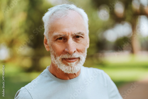 Portrait of handsome, smiling senior man looking at camera, posing outdoors, closeup, copy space