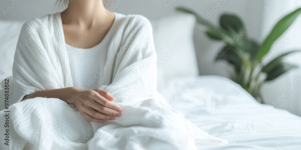 A serene moment of relaxation on a cozy bed, featuring a woman in a white blanket, surrounded by a peaceful indoor environment. A serene moment of relaxation on a cozy bed, featuring a woman in a white blanket, surrounded by a peaceful indoor environment.