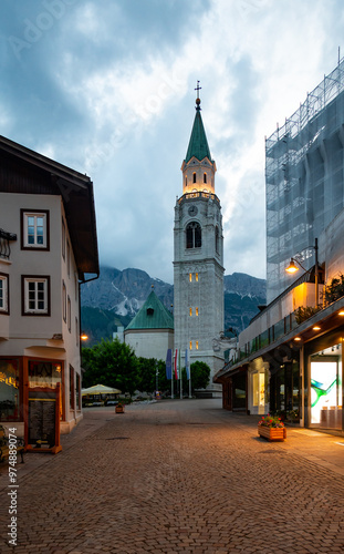 Obraz na płótnie A view of the iconic church tower in the heart of Cortina d'Ampezzo. The architectural beauty of the tower stands tall against the backdrop of the surrounding Alpine scenery w salonie