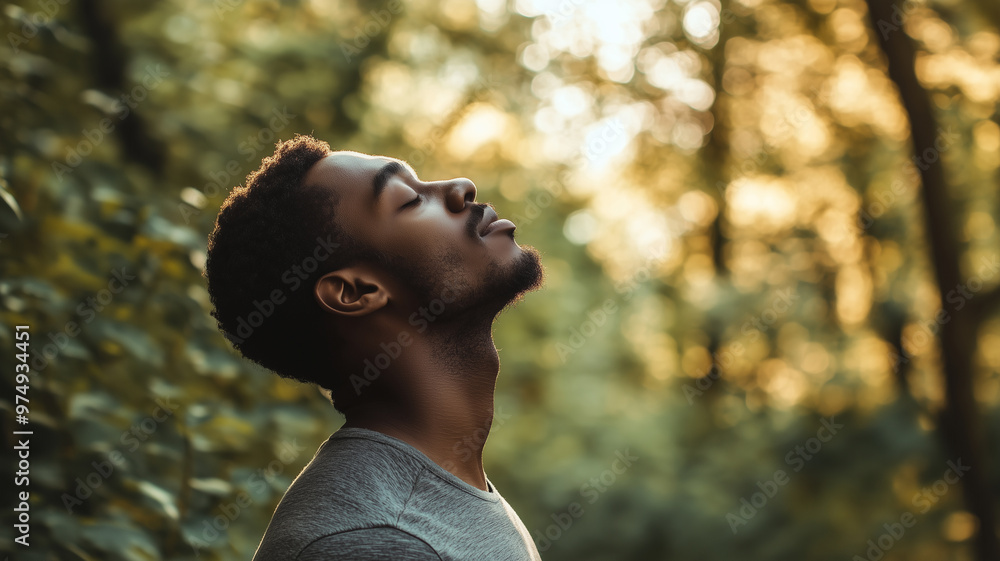 Black male model breaths fresh air in the forest. Portrait of an attractive black model, foliage in the background. Enjoying being outdoors. Enjoying clean air, sustainable theme. Tranquility, mental Black male model breaths fresh air in the forest. Portrait of an attractive black model, foliage in the background. Enjoying being outdoors. Enjoying clean air, sustainable theme. Tranquility, mental