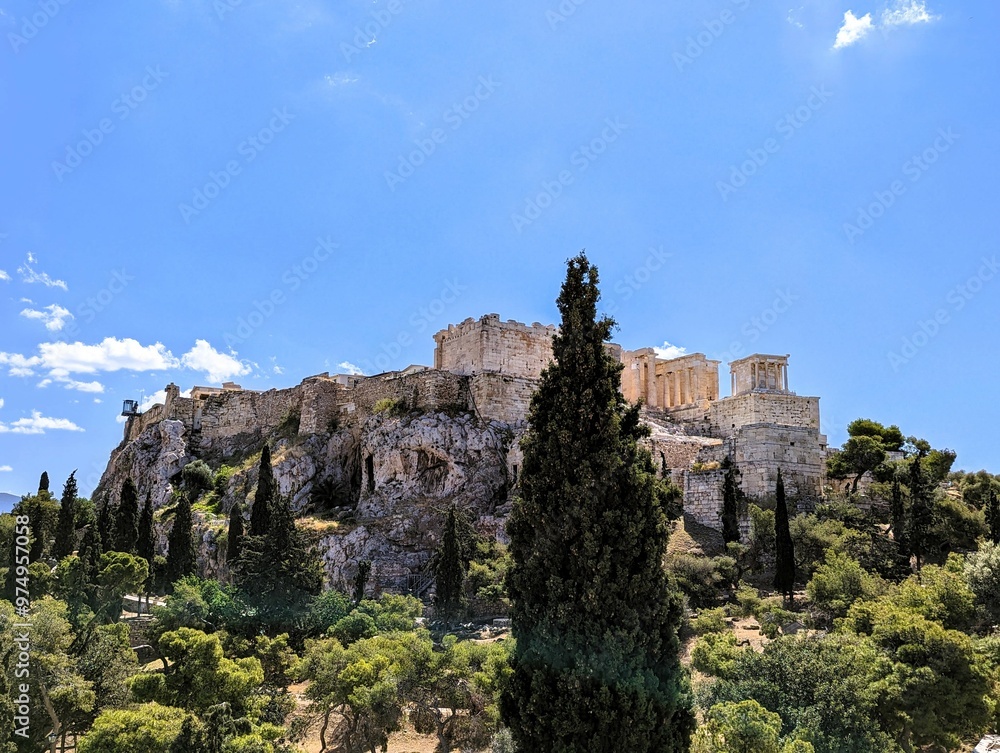 Panoramic view over the Acropolis and the temple of the Parthenon with a tall green cypress tree in the foreground in Athens, Greece, Europe. Panoramic view over the Acropolis and the temple of the Parthenon with a tall green cypress tree in the foreground in Athens, Greece, Europe.