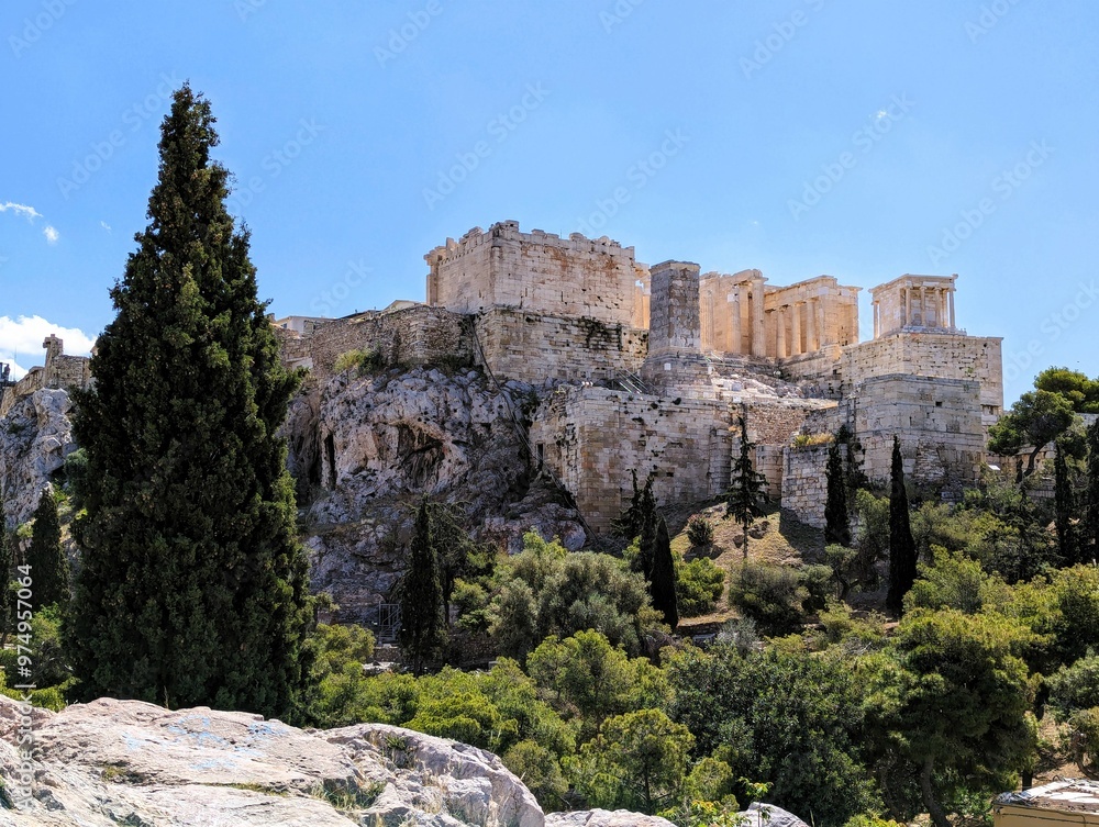 Panoramic view over the Acropolis and the temple of the Parthenon with a tall green cypress tree in the foreground in Athens, Greece, Europe. Panoramic view over the Acropolis and the temple of the Parthenon with a tall green cypress tree in the foreground in Athens, Greece, Europe.