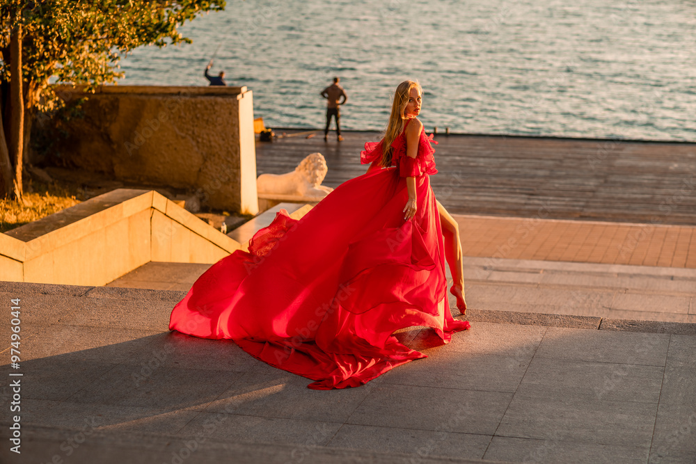 Sunrise red dress. A woman in a long red dress against the backdrop of sunrise, bright golden light of the sun's rays. The concept of femininity, harmony. Sunrise red dress. A woman in a long red dress against the backdrop of sunrise, bright golden light of the sun's rays. The concept of femininity, harmony.