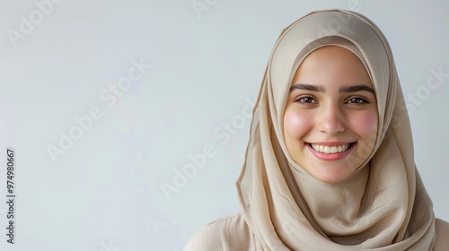 Portrait of young smiling muslim woman wearing a white hijab over white background studio photo