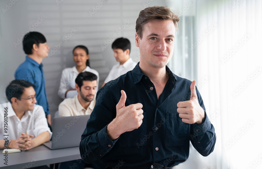 Confidence and happy smiling businessman portrait with background of his colleague and business team working in office. Office worker teamwork and positive workplace concept. Prudent Confidence and happy smiling businessman portrait with background of his colleague and business team working in office. Office worker teamwork and positive workplace concept. Prudent