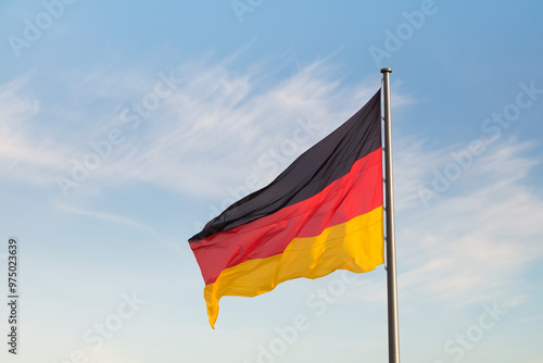 Waving German flag closeup on blue sky backgraund
