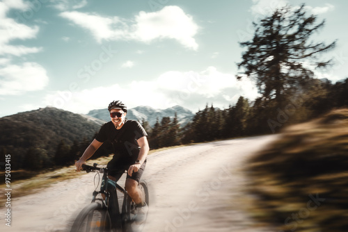 Mann mit Bart und kurzer Kleidung mit Fahrradhelm fährt mit seinem Mountainbike durch die Bikewelt Karnische Alpen in Nassfeld in Kärnten Österreich