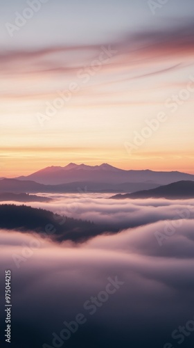 Sunset over misty mountains with cloud layers, tranquil atmosphere. Nature and serenity concept