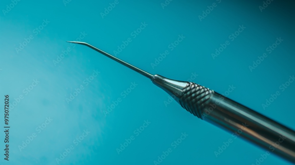 A sleek dental tool with a fine, sharp point rests against a cool, blue background, emphasizing precision and clinical sterilization. A sleek dental tool with a fine, sharp point rests against a cool, blue background, emphasizing precision and clinical sterilization.