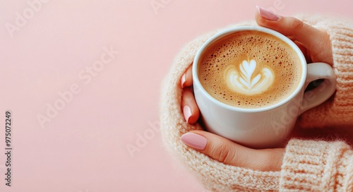 A cozy moment with a warm cup of latte art against a pastel pink background