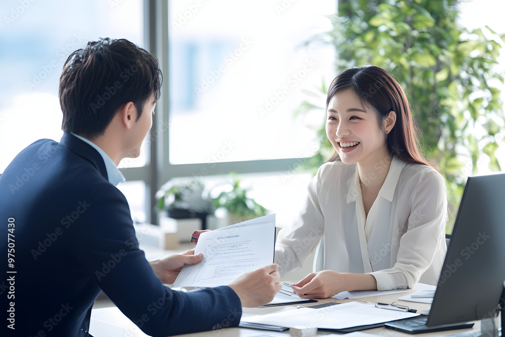 Young Japanese man and woman in casual working together at an office desk Young Japanese man and woman in casual working together at an office desk