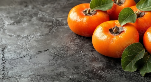 Freshly harvested citrus fruits on a textured stone surface in a dimly lit ki...