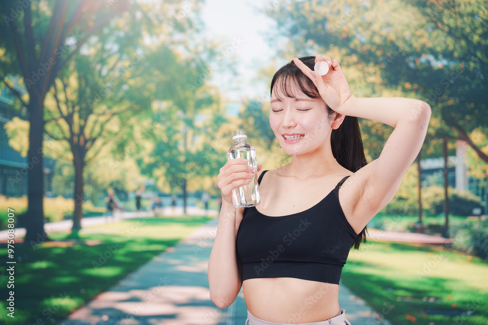 外でランニングをしながら水を飲む若い女性 外でランニングをしながら水を飲む若い女性