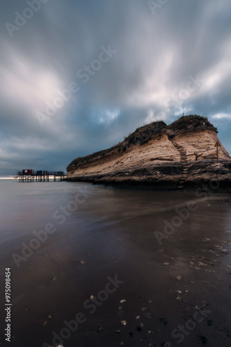 Sunset seascape along the coastline with traditional carrelets in Charente-Maritime in France