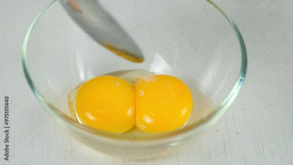 Putting egg yolk to glass bowl cooking food on kitchen at home. Recipe cuisine culinary ingredient. Baking, preparing eggs dish. Healthy organic protein in chicken eggs. Putting egg yolk to glass bowl cooking food on kitchen at home. Recipe cuisine culinary ingredient. Baking, preparing eggs dish. Healthy organic protein in chicken eggs.