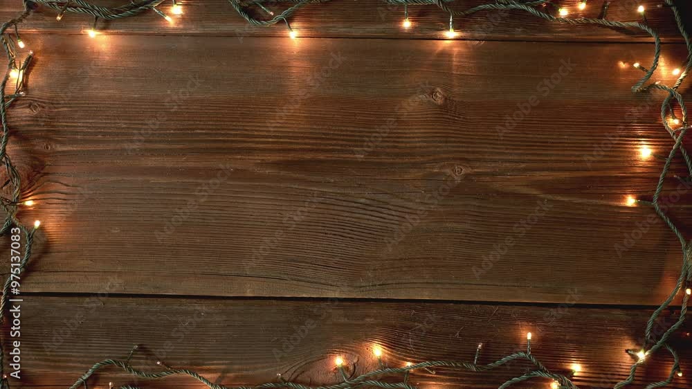 Christmas lights frame loop on rustic wooden background. Realistic garland on old wooden planks. 
