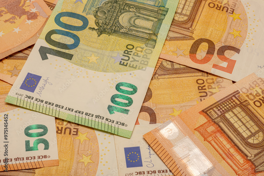 A stack of Euro banknotes with the numbers 100 and 50. The banknotes are mixed up. A stack of Euro banknotes with the numbers 100 and 50. The banknotes are mixed up.
