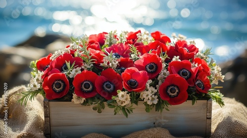 A unique bouquet featuring red anemones and star-shaped anise branches in a small, rustic wooden crate. 