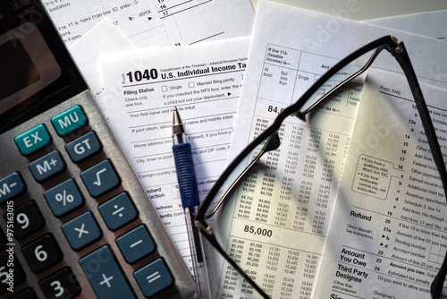 US tax return. 1040 individual income form. Calculator and points on tax returns. Documents for financial control in USA. Accounting papers with 1040 logo. Tax accounting in USA. Accounting, audit