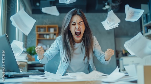 Asian millennial entrepreneur or female office worker who is screaming, shouting, and hurling papers at her desk, full of rage, fury, and madness. Depression, exhaustion, and failure. 