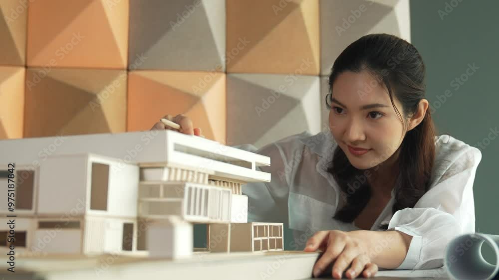 Closeup of professional asian female architect engineer looking while checking at house model at office. Checking real estate house. Business design and building construction concept. Manipulator. Closeup of professional asian female architect engineer looking while checking at house model at office. Checking real estate house. Business design and building construction concept. Manipulator.