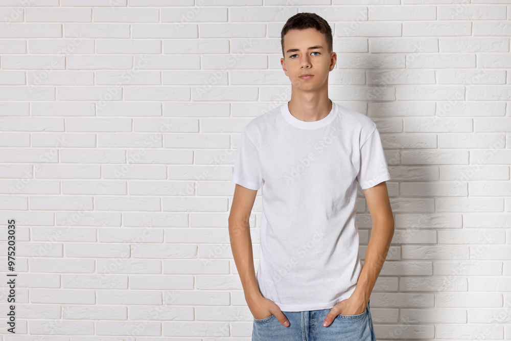 Teenage boy wearing t-shirt near white brick wall, space for text Teenage boy wearing t-shirt near white brick wall, space for text