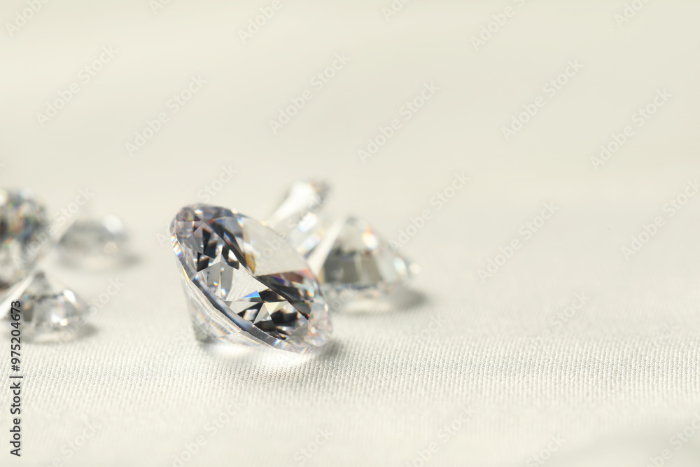 Many beautiful shiny diamonds on white fabric, closeup. Space for text Many beautiful shiny diamonds on white fabric, closeup. Space for text