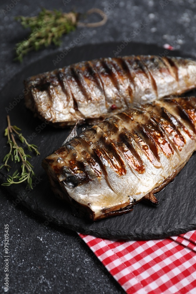 Delicious grilled mackerel, thyme and napkin on dark textured table, closeup Delicious grilled mackerel, thyme and napkin on dark textured table, closeup