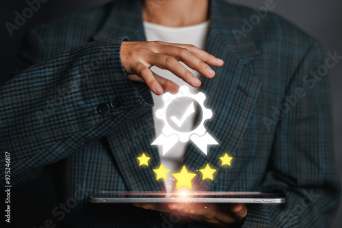 A person holding a tablet with a digital certification badge and stars, symbolizing quality assurance, standards, and excellence. photo