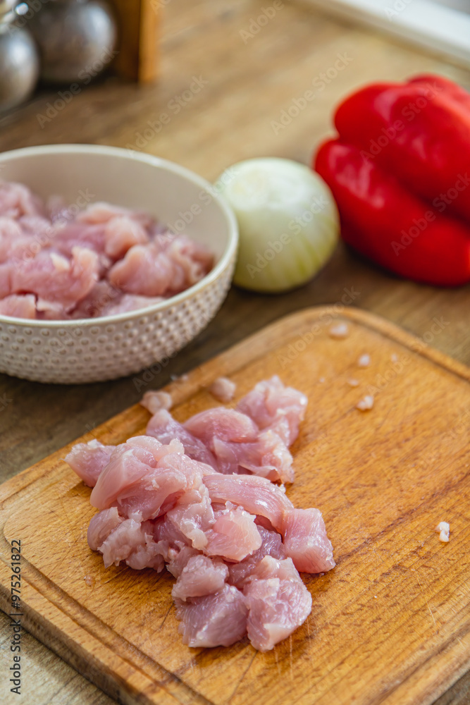 Pieces of fillet on a cutting board, onion and red pepper on the side Pieces of fillet on a cutting board, onion and red pepper on the side