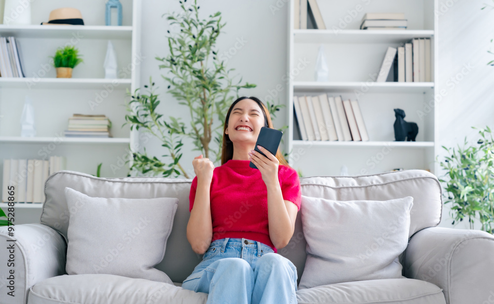 Happy young asian woman relax on comfortable couch at home texting messaging on smartphone, smiling girl use cellphone, chatting online message, shopping online from home Happy young asian woman relax on comfortable couch at home texting messaging on smartphone, smiling girl use cellphone, chatting online message, shopping online from home