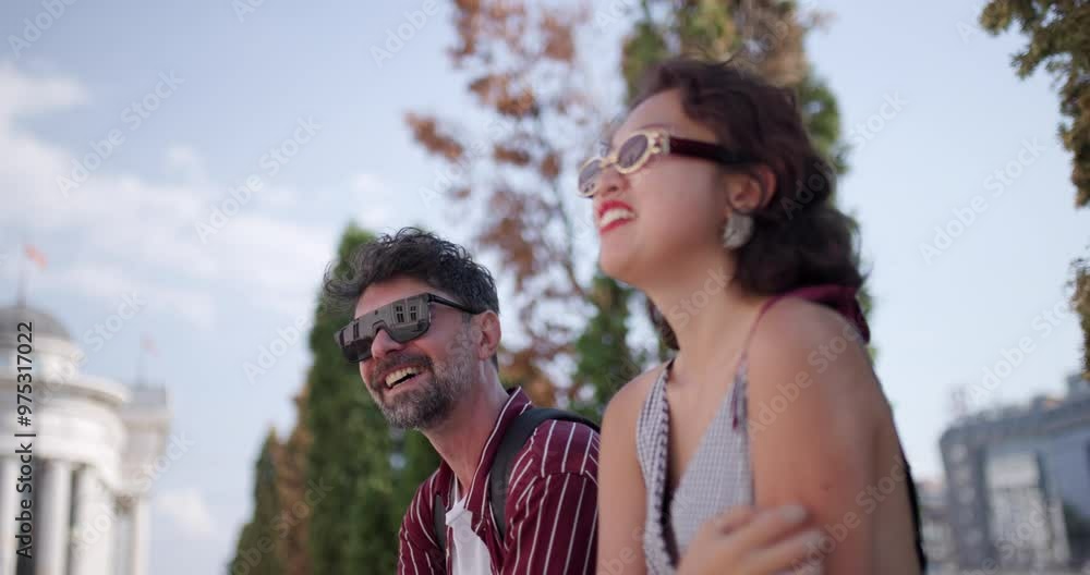 Outdoor conversation between smiling friends enjoying a sunny day with a scenic backdrop Outdoor conversation between smiling friends enjoying a sunny day with a scenic backdrop