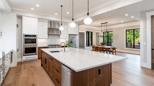 Modern kitchen interior with large island, wooden cabinets, and sleek appliances in a spacious open-plan home