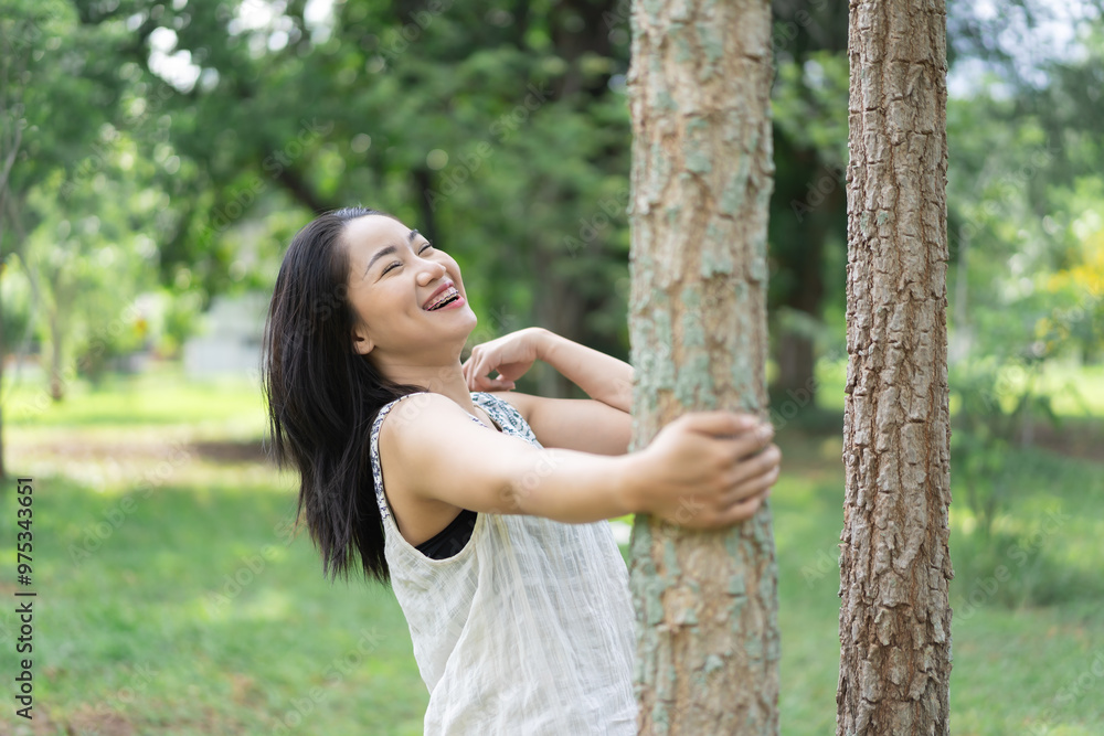 Happy young woman looks cheerful and relaxed in a quiet environment in the middle of a garden. Summer time. Spending time in nature. Maintaining a healthy lifestyle happy lifestyle. Happy young woman looks cheerful and relaxed in a quiet environment in the middle of a garden. Summer time. Spending time in nature. Maintaining a healthy lifestyle happy lifestyle.