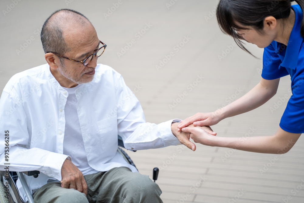 Obraz premium 車いすから立ち上がる介助をする介護施設スタッフ