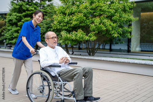 車いすのシニア男性と介護施設スタッフ