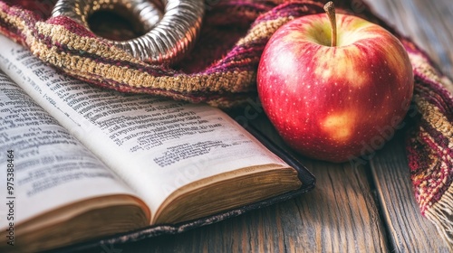 Close-up of a shofar, Hebrew prayer book, and apple on a table as symbols for Rosh Hashanah, representing the Jewish New Year traditions of faith, reflection, and renewal photo