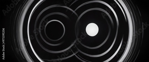 The image is a black and white abstract composition featuring concentric circles and a central white circle, creating a sense of depth and movement.