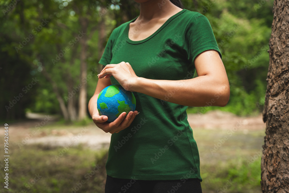 Forest conservationist holds small globe in hands, symbolizing global responsibility for protecting planet. Standing outdoors in green park, sustainability, commitment to achieving net-zero impact. Forest conservationist holds small globe in hands, symbolizing global responsibility for protecting planet. Standing outdoors in green park, sustainability, commitment to achieving net-zero impact.