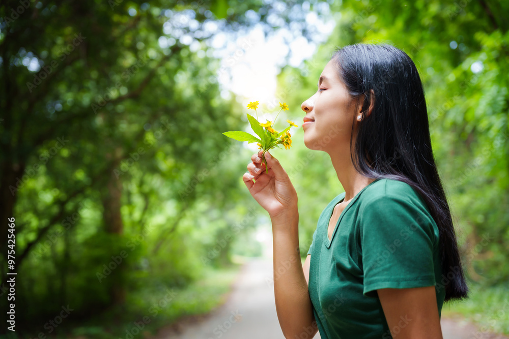 A cheerful young asian woman enjoys a sunny day outdoors, holding a vibrant bunch of yellow flowers. Smiling in a green field, she embodies the joy and freedom of summer in the countryside. A cheerful young asian woman enjoys a sunny day outdoors, holding a vibrant bunch of yellow flowers. Smiling in a green field, she embodies the joy and freedom of summer in the countryside.
